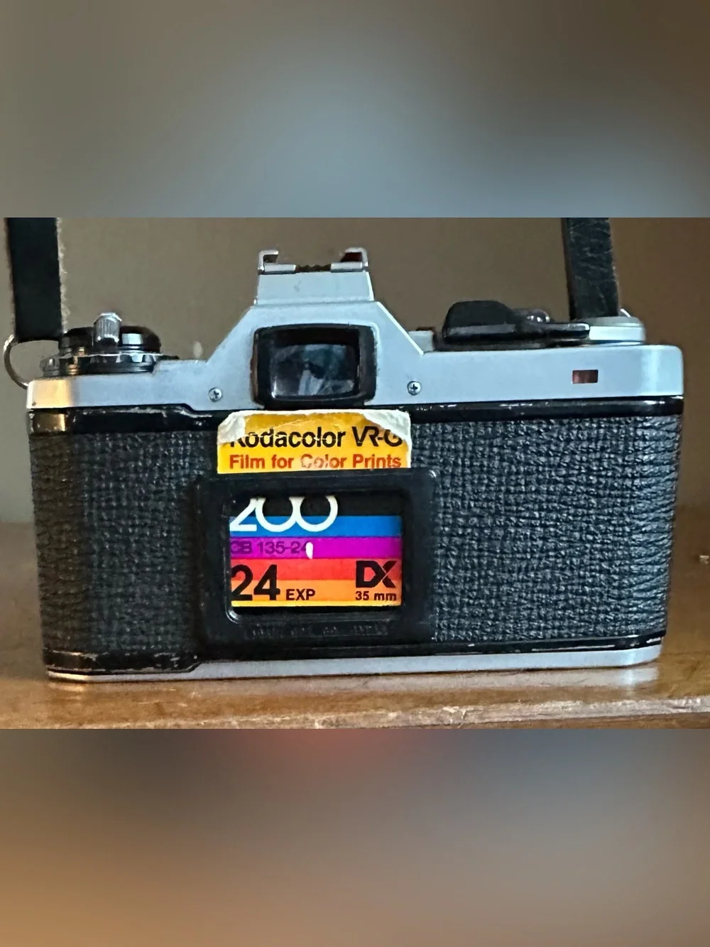 Pentax Silver and Black SLR Camera with Black Lens Cap and Colorful Strap